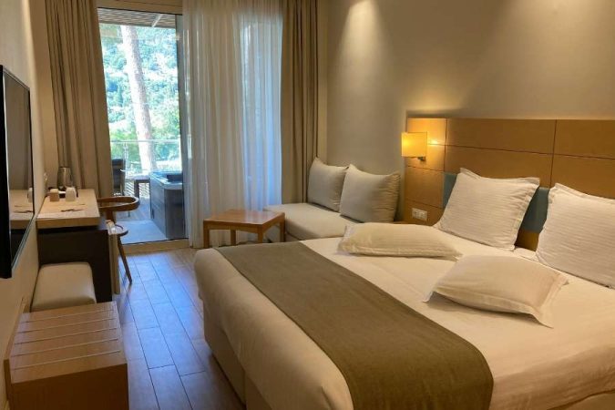 Une chambre d'amis moderne et lumineuse avec un grand lit double et un accès balcon.