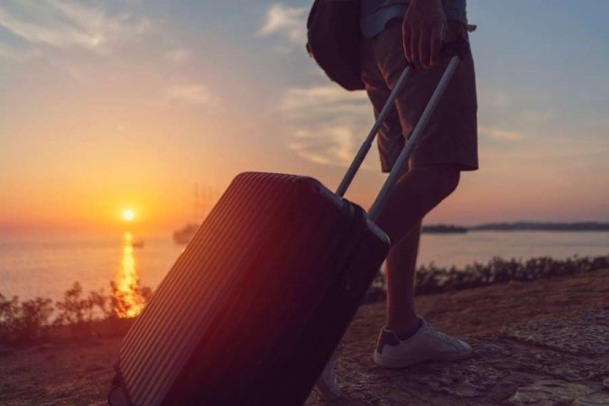 Un voyageur marche au coucher du soleil, prêt à entreprendre de longs trajets en toute sérénité.
