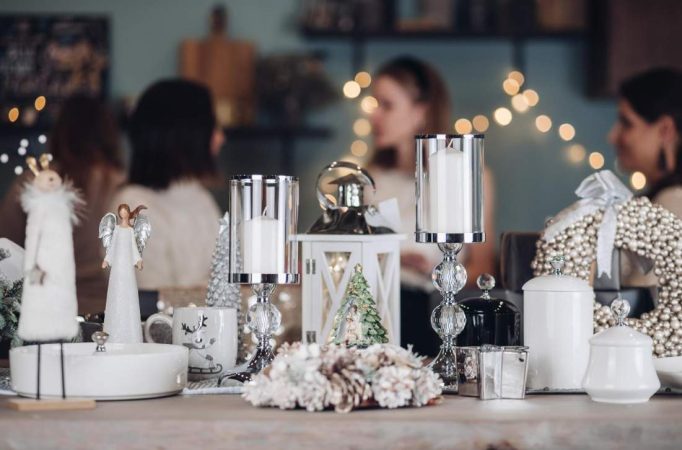 Centre de table de fête orné de photophores en verre, bougies blanches et guirlandes lumineuses pour illustrer des idees decoration mariage d hiver chaleureux.