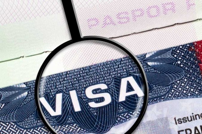 Une loupe posée sur un passeport met en avant les démarches administratives indispensables pour l'obtention du Dubai Golden Visa.
